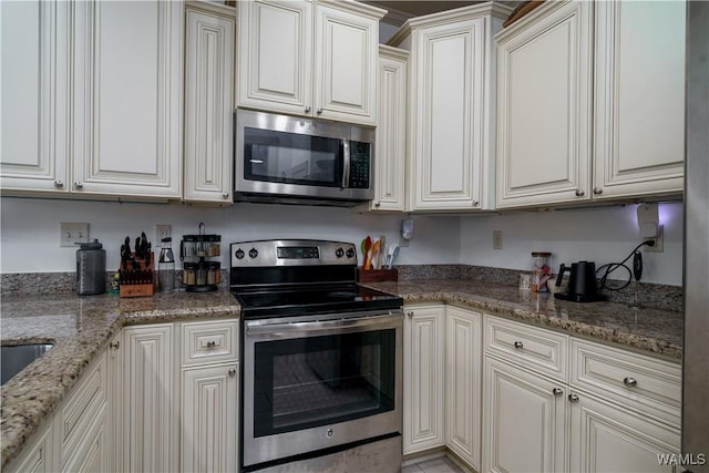 kitchen featuring stainless steel appliances, white cabinetry, and stone countertops