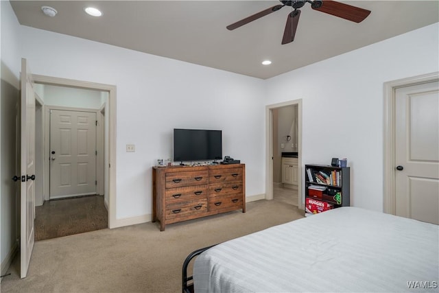 bedroom with ceiling fan, ensuite bathroom, and light carpet