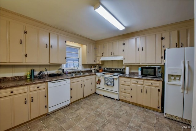 kitchen featuring sink, white appliances, and cream cabinetry