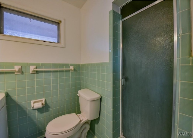 bathroom featuring tile walls, a shower with door, and toilet