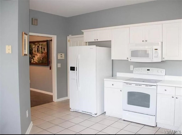 kitchen with white cabinetry, light tile patterned floors, and white appliances