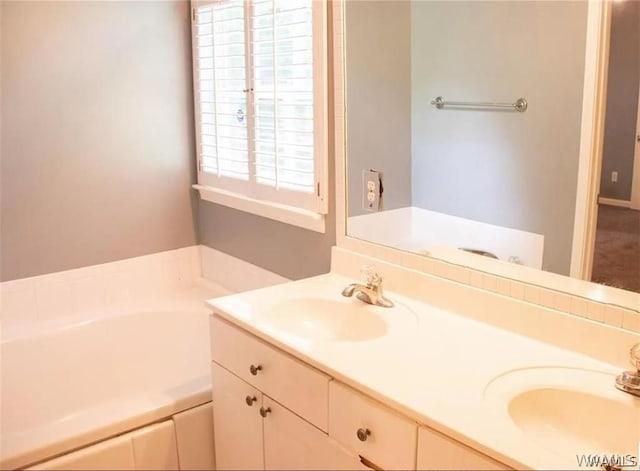 bathroom featuring a washtub and vanity