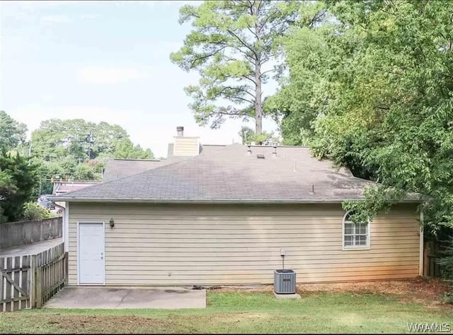 back of house with a yard and central air condition unit