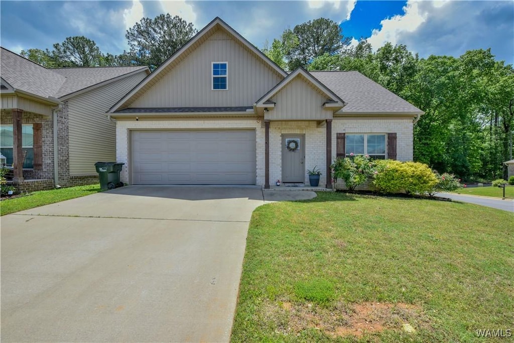 5205 University Gardens Dr, Cottondale, AL 35453 - view of front of home with driveway, board and batten siding, brick siding, an attached garage, and a front lawn