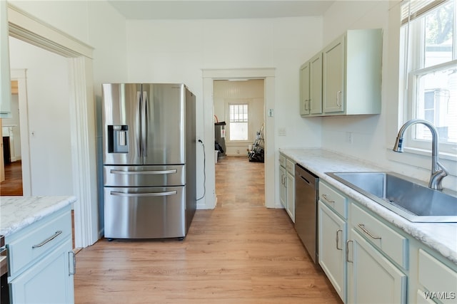 kitchen with a wealth of natural light, sink, light hardwood / wood-style floors, and appliances with stainless steel finishes