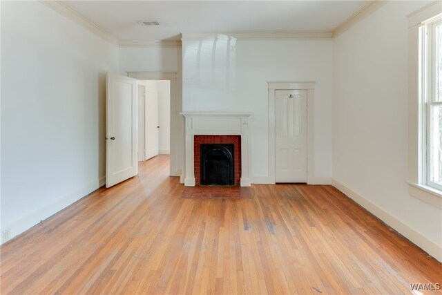 unfurnished living room with a fireplace, crown molding, and light hardwood / wood-style flooring