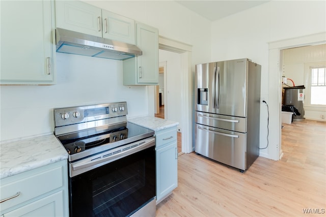 kitchen featuring light hardwood / wood-style floors, light stone counters, stainless steel appliances, and water heater