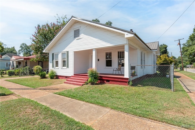 bungalow-style home featuring covered porch and a front lawn