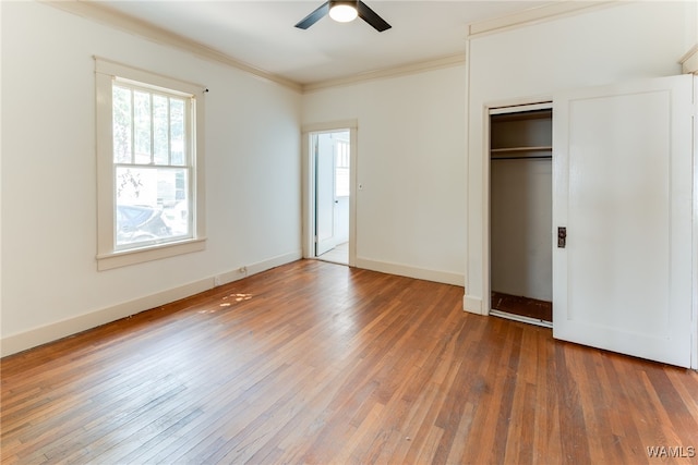 unfurnished bedroom featuring ceiling fan, a closet, dark hardwood / wood-style floors, and ornamental molding