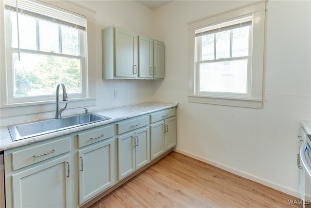 kitchen with gray cabinetry, light hardwood / wood-style floors, and sink