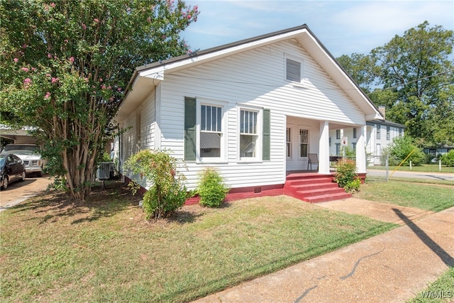 bungalow-style house with a porch, a front yard, and central AC