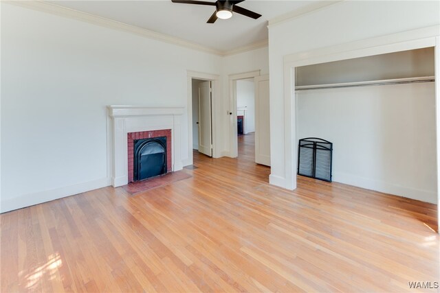 unfurnished bedroom featuring light wood-type flooring, a brick fireplace, ceiling fan, crown molding, and a closet