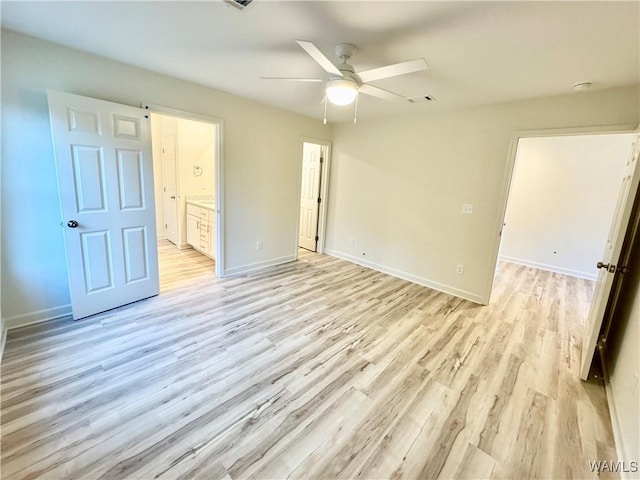 unfurnished bedroom with light wood finished floors, connected bathroom, baseboards, and ceiling fan