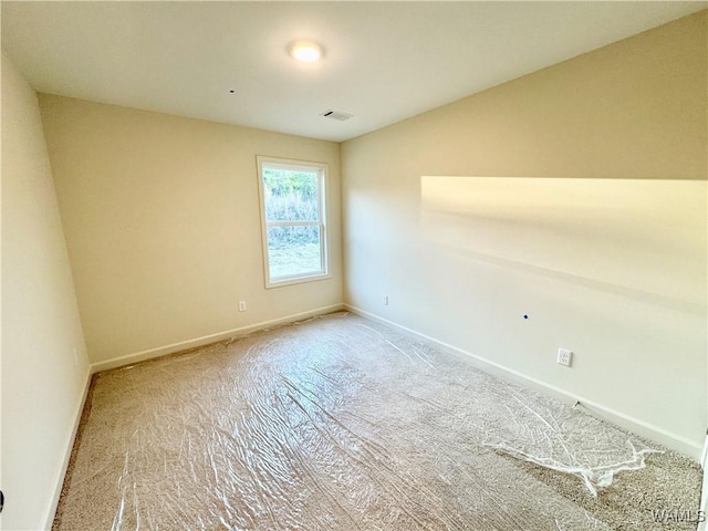 empty room featuring baseboards and visible vents