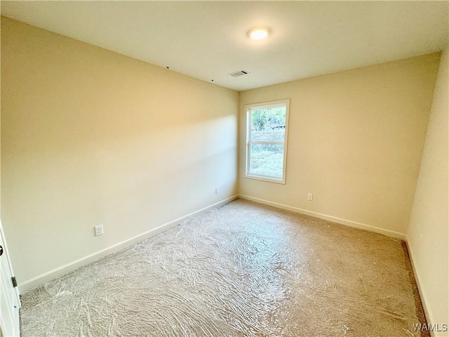 carpeted empty room featuring visible vents and baseboards