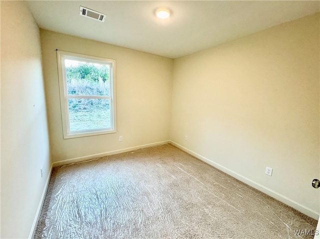 carpeted empty room with visible vents and baseboards