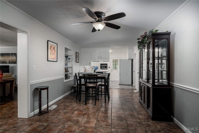 4228 Pelham Heights Rd, Tuscaloosa, AL 35405 - dining room featuring a ceiling fan, ornamental molding, baseboards, and dark tile patterned flooring