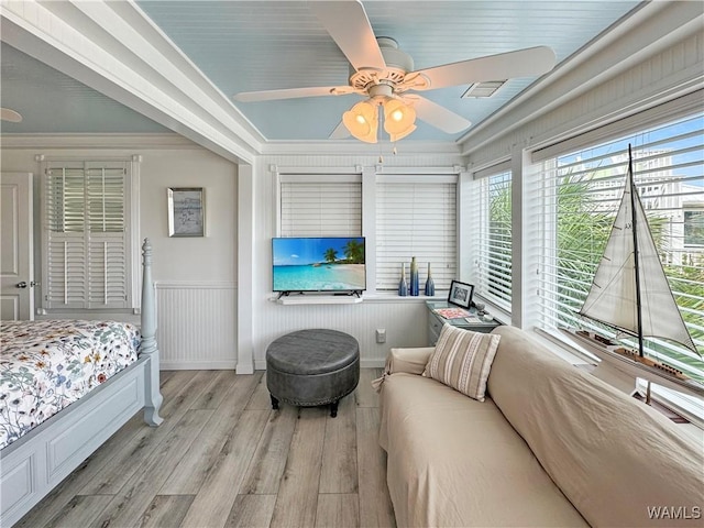 bedroom featuring visible vents, a ceiling fan, wood finished floors, and crown molding