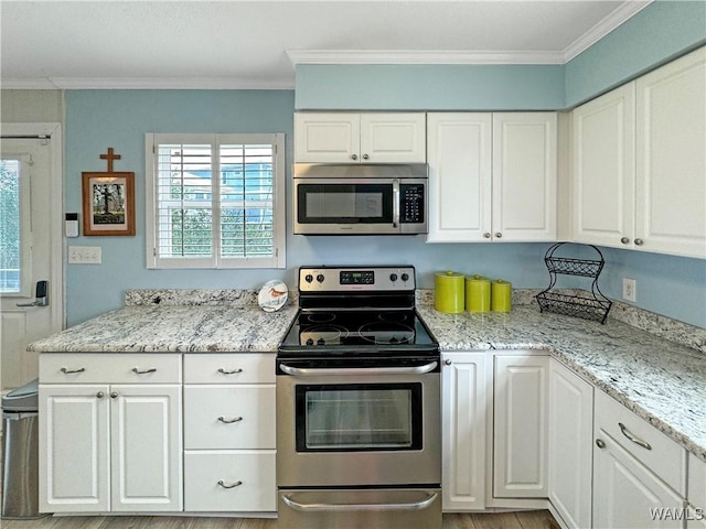 kitchen with appliances with stainless steel finishes, crown molding, and white cabinetry