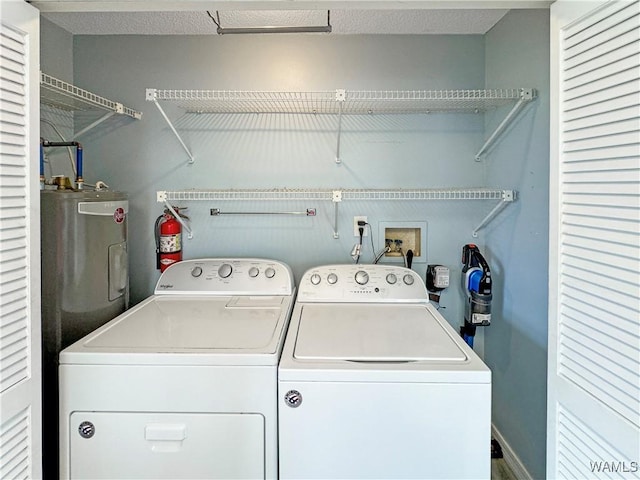 washroom with laundry area, washing machine and dryer, and water heater