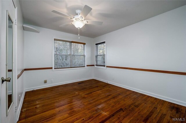 empty room featuring visible vents, wood finished floors, baseboards, and ceiling fan