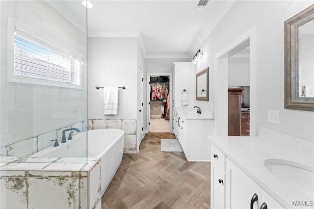 13880 Glenview Dr, Northport, AL 35475 - bathroom featuring two vanities, a freestanding bath, a walk in closet, and ornamental molding
