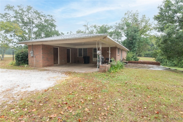 back of property featuring a carport and a yard