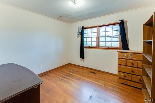 interior space with light hardwood / wood-style floors and ornamental molding