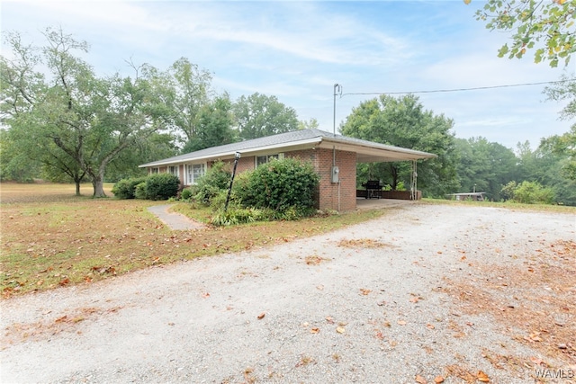 view of side of home with a carport and a yard