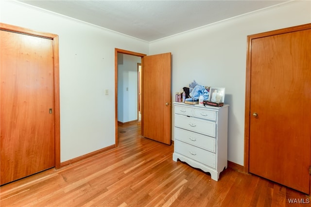 bedroom with light hardwood / wood-style floors, a closet, and ornamental molding