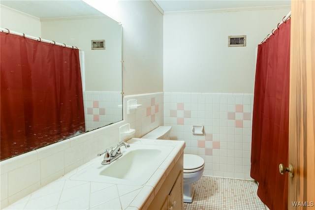 bathroom featuring tile patterned floors, toilet, crown molding, and tile walls