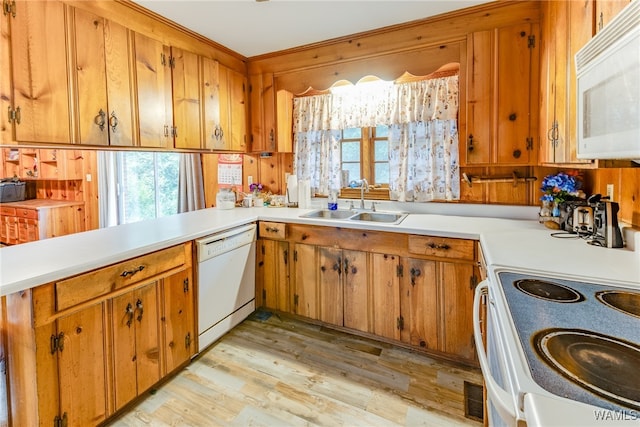 kitchen with kitchen peninsula, white appliances, crown molding, sink, and light hardwood / wood-style flooring