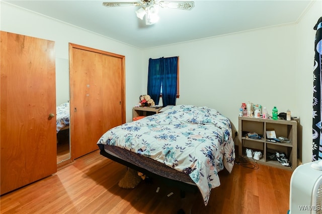 bedroom featuring ceiling fan, a closet, ornamental molding, and hardwood / wood-style flooring