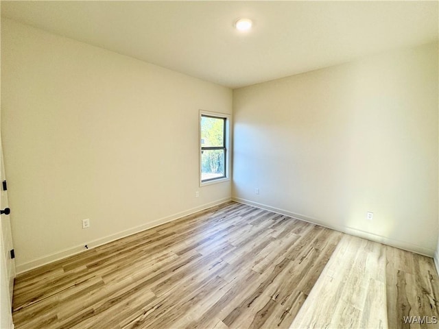 unfurnished room with baseboards and light wood-style floors