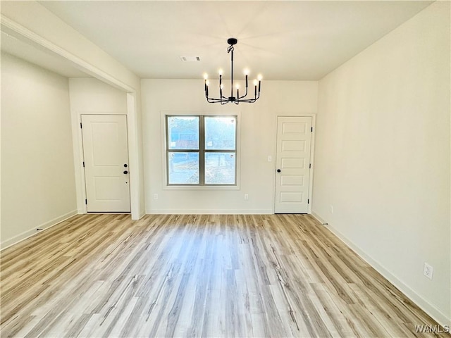 unfurnished dining area featuring an inviting chandelier, baseboards, visible vents, and light wood finished floors