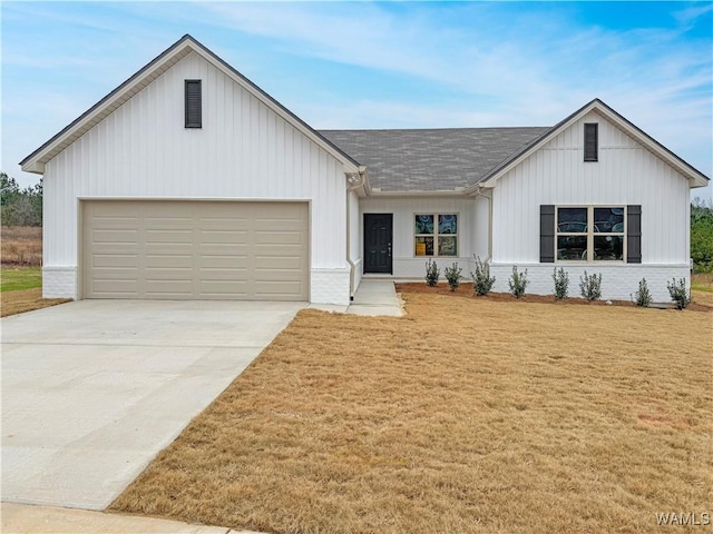 modern inspired farmhouse featuring a garage and a front yard