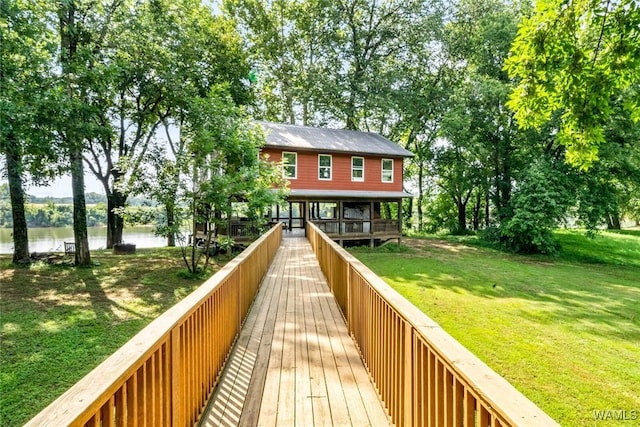 back of house with a water view and a lawn