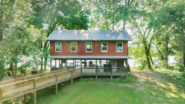 rear view of house with a wooden deck and a lawn