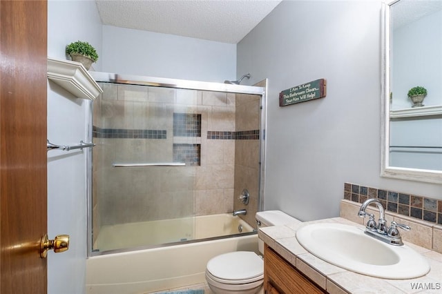 full bathroom with enclosed tub / shower combo, vanity, toilet, and a textured ceiling