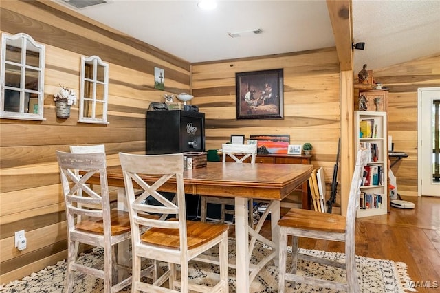 dining room with hardwood / wood-style flooring and wooden walls