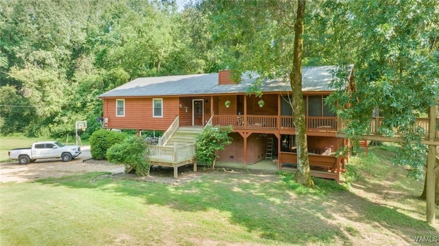 rear view of house with a deck and a lawn