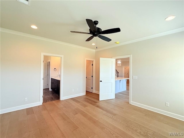 unfurnished bedroom featuring crown molding, ensuite bathroom, light wood-style flooring, baseboards, and recessed lighting