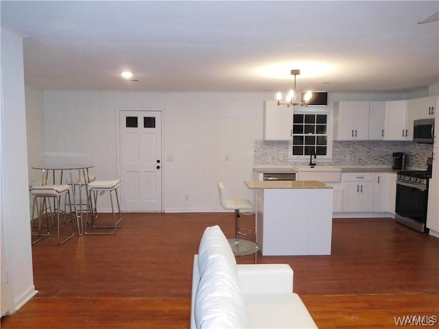 kitchen featuring pendant lighting, dark hardwood / wood-style floors, white cabinetry, and appliances with stainless steel finishes