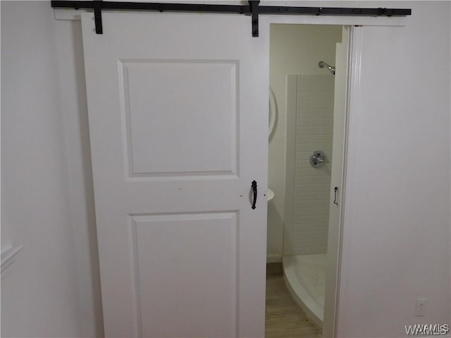 bathroom featuring hardwood / wood-style flooring and tiled shower