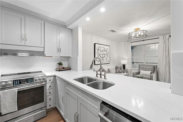 1228 8th St Unit 412, Tuscaloosa, AL 35401 - kitchen featuring appliances with stainless steel finishes, under cabinet range hood, ornamental molding, light stone countertops, and open floor plan