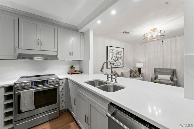 1228 8th St Unit 412, Tuscaloosa, AL 35401 - kitchen with stainless steel appliances, gray cabinetry, under cabinet range hood, ornamental molding, and light stone countertops