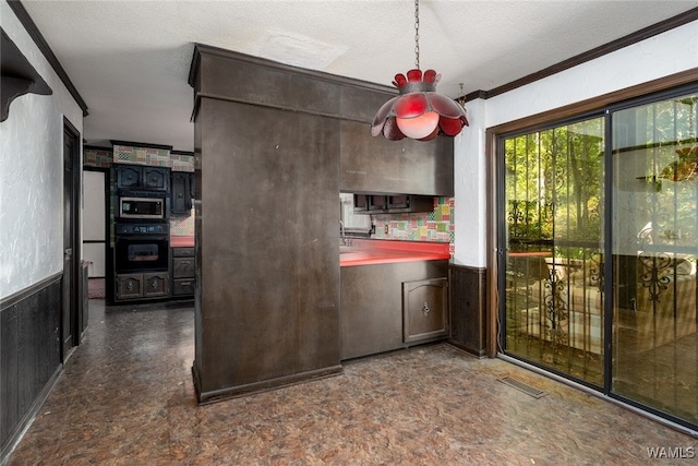 kitchen featuring a textured ceiling, black oven, and ornamental molding