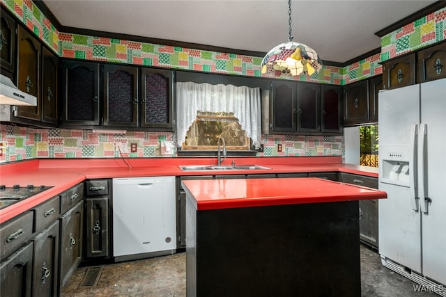 kitchen with pendant lighting, white appliances, crown molding, sink, and a kitchen island