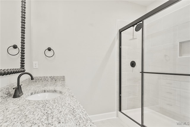 bathroom featuring tile patterned flooring, vanity, and an enclosed shower