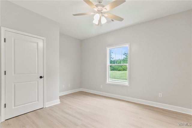 empty room with ceiling fan and light hardwood / wood-style flooring